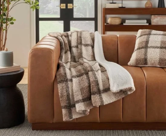 Cozy plaid throw on brown leather couch